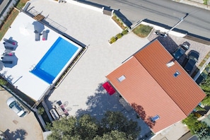 A rooftop swimming pool with lounge chairs and a covered seating area. - Villa in Kornic, Krk with swimming pool (Kornic, Krk)