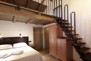 Une chambre à coucher avec un lit, une armoire et un escalier.
