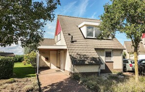 A two-story house with a tiled roof, a visible chimney, and a front door. - Nice home in Stevensweert with WiFi (Stevensweert)