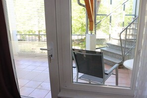 A door leading to a balcony with a metal chair and a staircase. - Becker Holiday Winery Apartment "Hasenläufer" (Burgen)