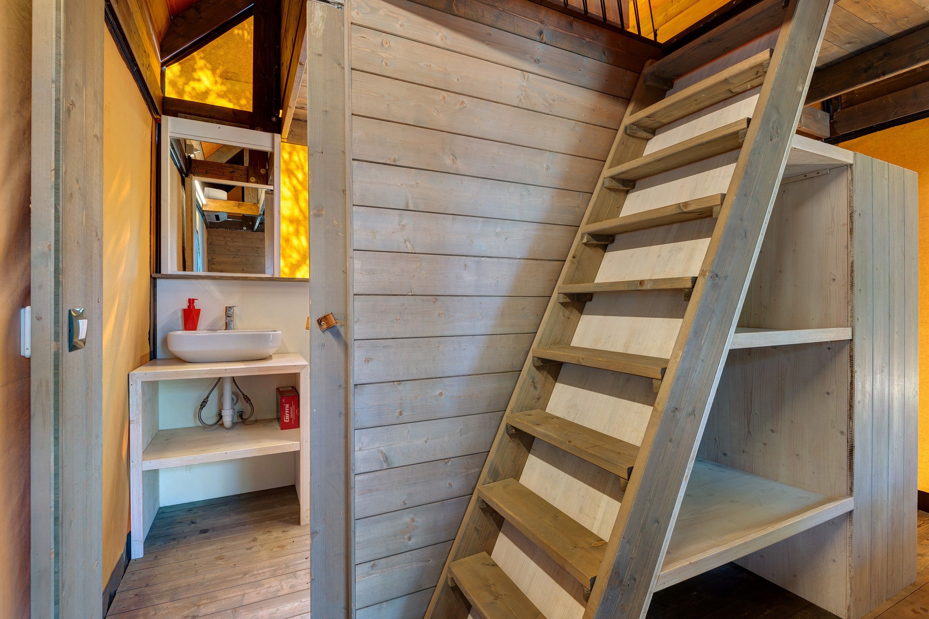 Un intérieur en bois avec une étagère intégrée et une échelle.