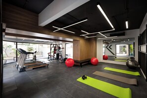 A gym with exercise equipment, treadmills, and exercise balls.
