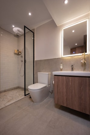 A modern bathroom with a shower, toilet, and vanity.