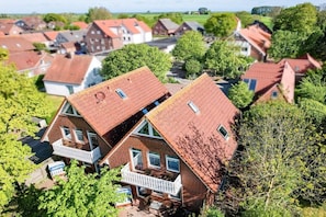 Ein Wohngebiet mit mehreren Häusern, die rote Ziegeldächer und Balkone haben.