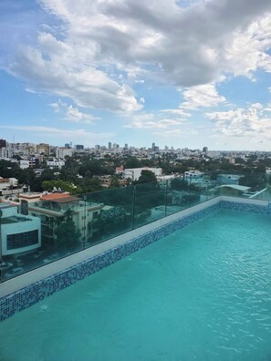 A rooftop pool with a cityscape view, surrounded by buildings and greenery. - Feel at Homewith Best View in the City Pool (Santo Domingo)
