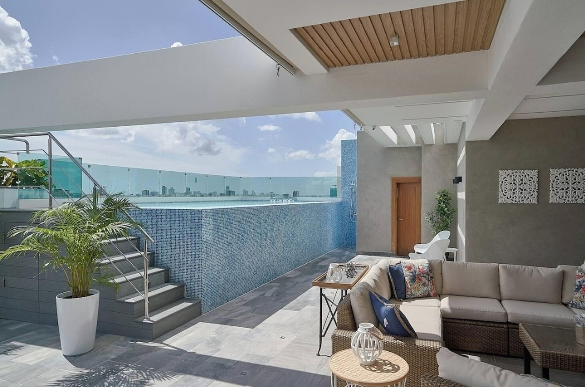 Um espaço moderno para atividades ao ar livre, com piscina, área de estar e escadaria para um andar superior.
