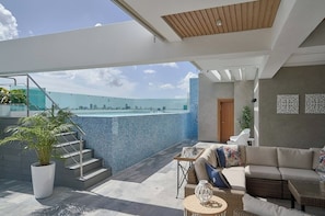 Um espaço moderno para atividades ao ar livre, com piscina, área de estar e escadaria para um andar superior.