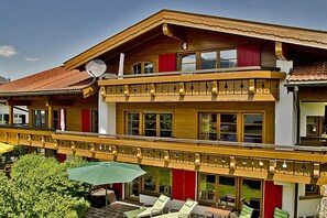 Ein zweistöckiges Gebäude mit Balkon, Außenbereich und einer Satellitenschüssel.