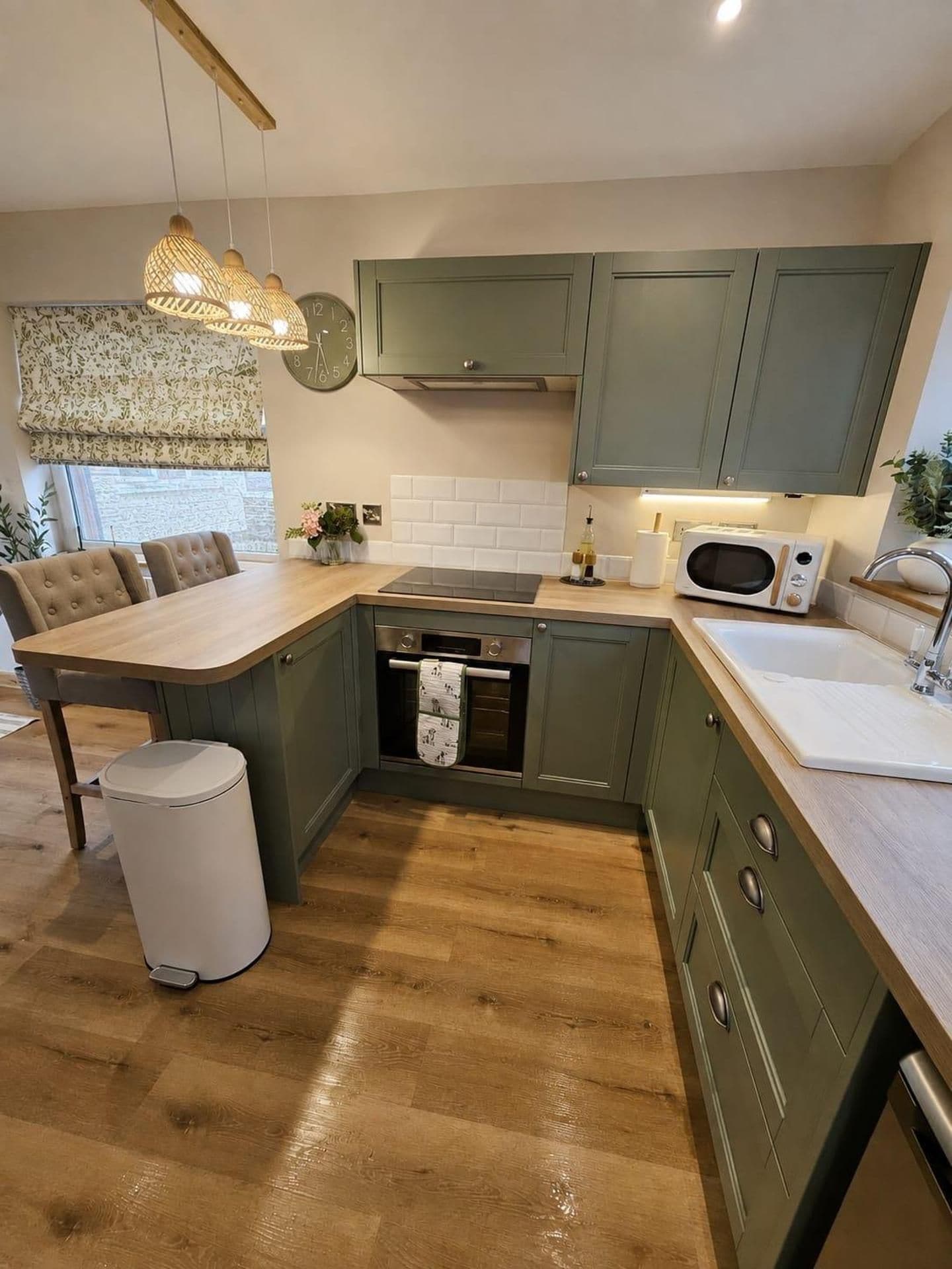 A modern kitchen with a central island, a microwave, and a sink.
