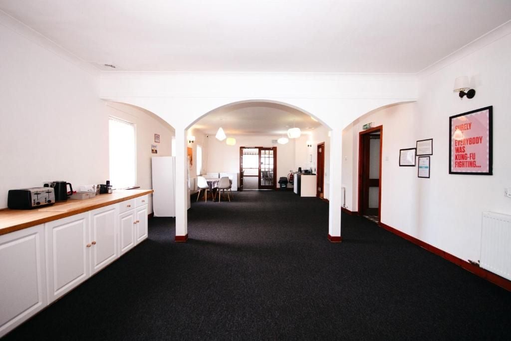 A corridor with a kitchen area on the left, a dining area in the center, and a reception desk on the right.