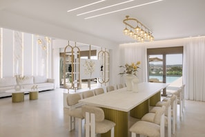 Un comedor moderno con una mesa larga, varias sillas y vistas al exterior.