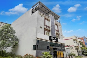 A modern building with a flat roof, large windows, and a sign indicating it is a serviced company. - Collection O Satya Sai Square (Indore)