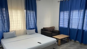 Un dormitorio con una cama, una mesita y una silla.