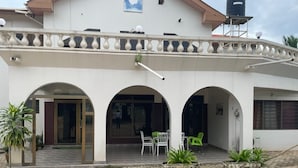 Un edificio con un patio cubierto, que presenta una serie de arcos y un suelo de baldosas.