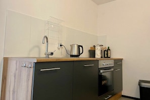 A compact kitchen with a sink, kettle, and a small oven. - Rosenstrasse Gallery (Kressbronn)