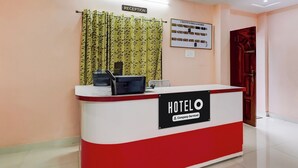 Bancada de recepção de hotel com sinalização indicando que é um hotel de serviço corporativo.