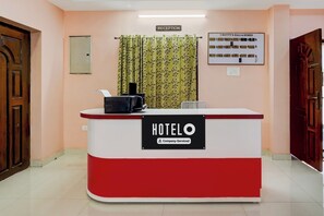 A reception desk with a sign indicating it is a company-serviced hotel. - OYO Hotel O GT Road Nellore (Nellore)