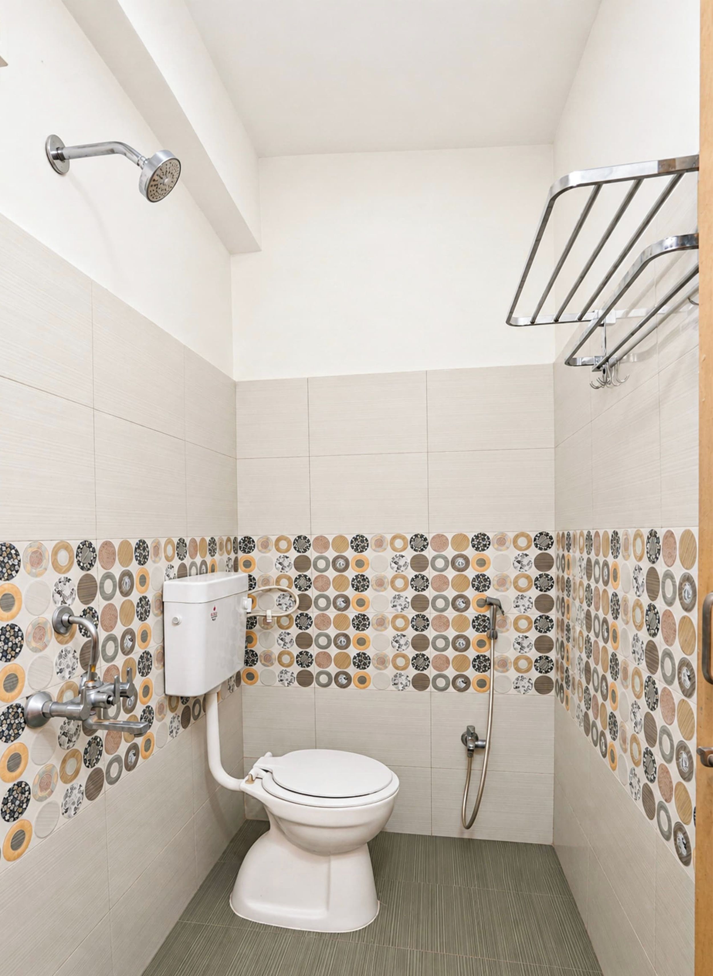 Pieni, moderni kylpyhuone, jossa on wc, suihku ja pyyheteline.
