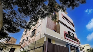 A multi-story hotel with a modern facade, a visible sign indicating it's a hotel, and a gated entrance. - OYO Hotel O GT Road Nellore (Nellore)