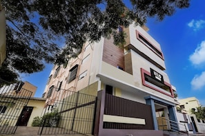 A multi-story hotel with a modern facade, a visible sign indicating it's a hotel, and a gated entrance. - OYO Hotel O GT Road Nellore (Nellore)