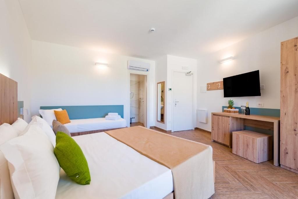 Ein Hotelzimmer mit Bett, Schreibtisch, Fernseher und Kleiderschrank.