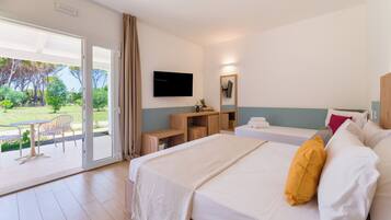 A hotel room with a bed, a desk, a TV, and a balcony with a table and chairs.