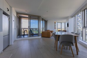 Eine moderne Küche mit Essbereich, großen Fenstern und Blick auf die Stadt.