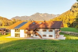 Una casa a due piani con tetto spiovente, ampie finestre e un balcone.