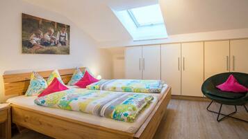 A bedroom with a wooden bed, a skylight, and a painting on the wall.