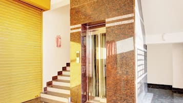 A staircase with a handrail, a fire extinguisher mounted on the wall, and a yellow sliding door.