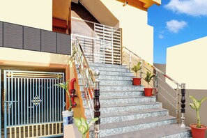 A staircase with metal railings and potted plants.