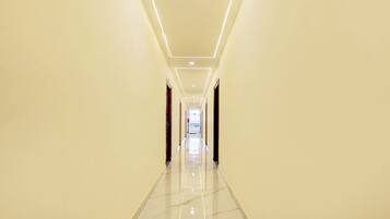 Un pasillo largo y estrecho con piso brillante e iluminación empotrada.