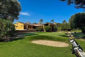 A golf course with a house in the background. - Villa in Cala Muarad with swimming pool (Cala Muarad)