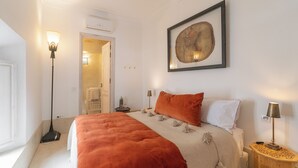 A bedroom with a large bed, a floor lamp, a bedside table, and a framed artwork on the wall. - Peaceful 5-Bedroom Riad in the Heart of Marrakech (Marrakesh)