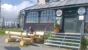 Un edificio de madera con un letrero que dice 'Gössler Bier' y una escalera que lleva a la entrada.