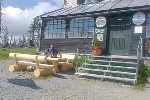 A wooden building with a sign that reads 'Gössler Bier' and a staircase leading to the entrance. - in the old forester's lodge (Riedlhütte)