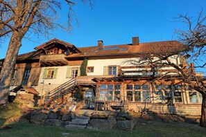 A traditional chalet with a wooden staircase, stone steps, and a balcony. - in the old forester's lodge (Riedlhütte)