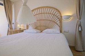 A bed with a headboard, a bedside lamp, and a wall-mounted light fixture. - Villa in Costa Calma with swimming pool (Costa Calma)
