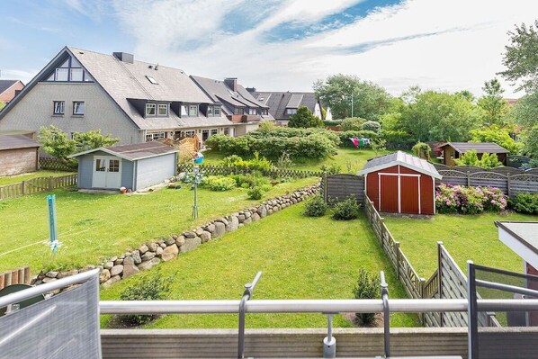 Ein Wohngebiet mit Häusern, einem kleinen Gartenhaus und einem gepflegten Rasen.
