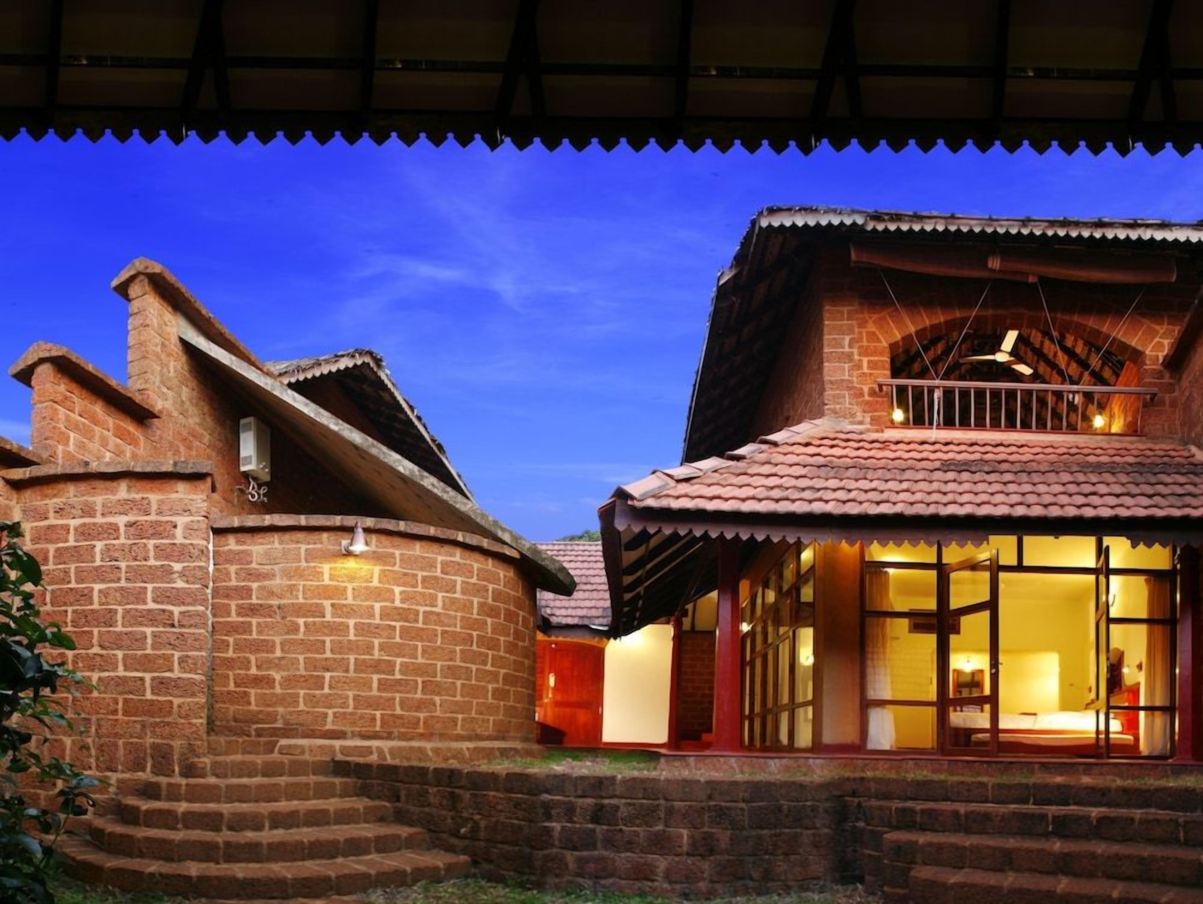 A brick building with a balcony and a staircase leading to the entrance.