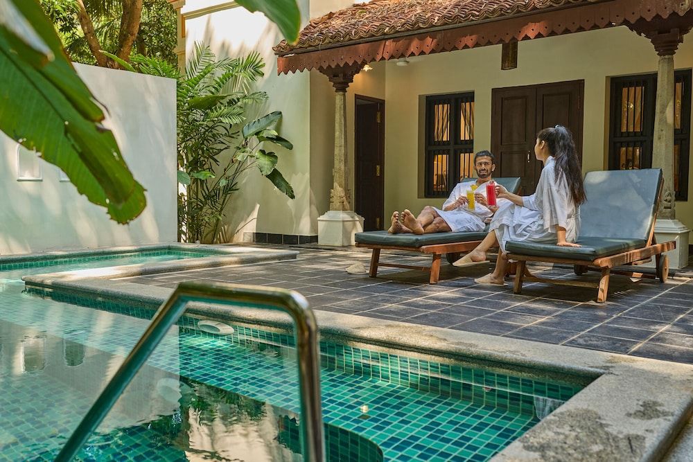 A pool area with lounge chairs and a tiled deck.
