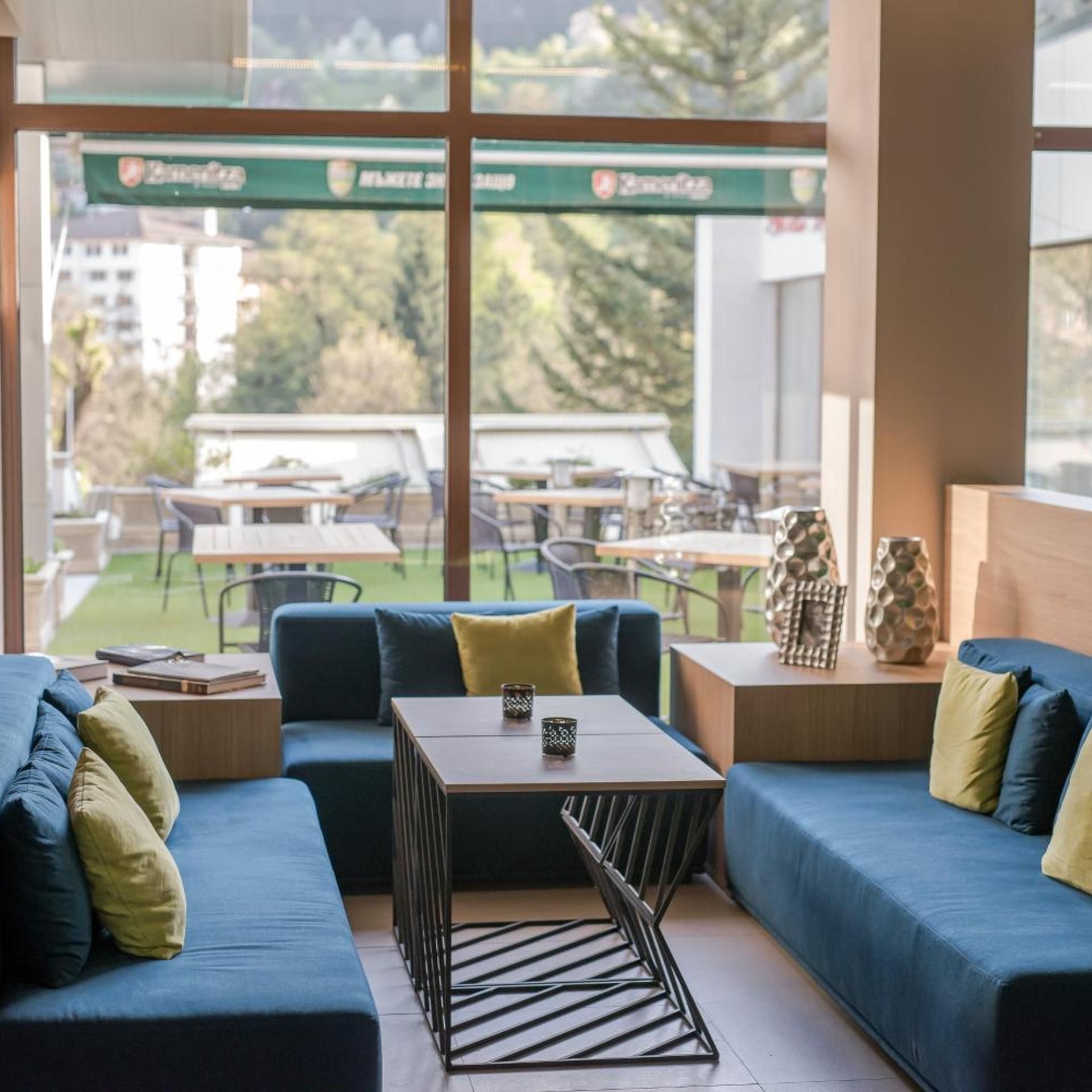 A modern interior with a sofa, a coffee table, and a view of an outdoor patio area.