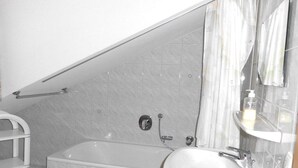 Een badkamer met een bad, een wastafel en een douche.