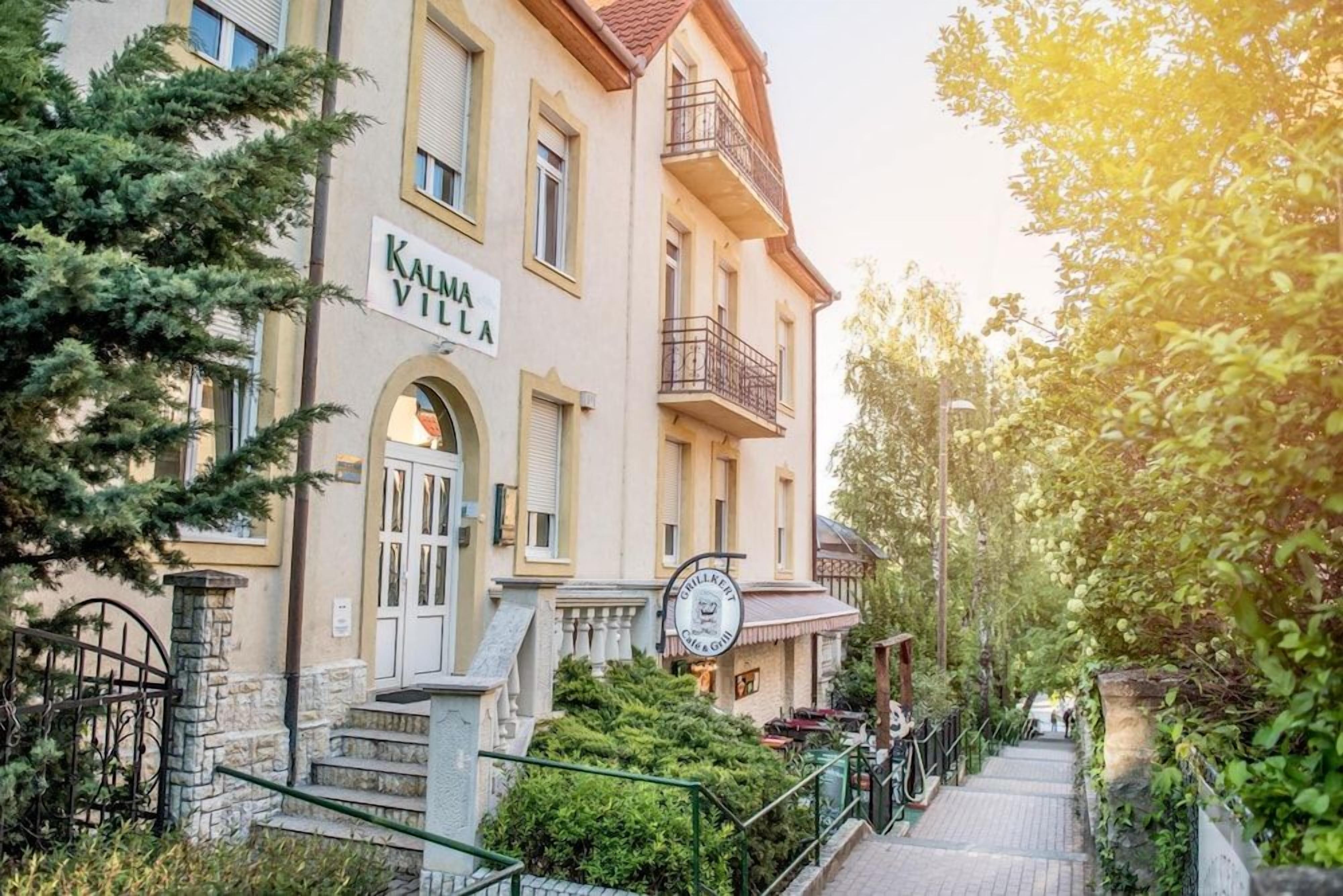 Un edificio con un letrero que dice 'KALMA VILLA' y un letrero de restaurante que dice 'CHILLBIRDS'.