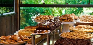 Un bufé con diversos productos de pastelería y bollería.