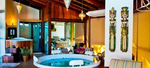 Habitación con piscina, techo de madera y decoración en la pared.