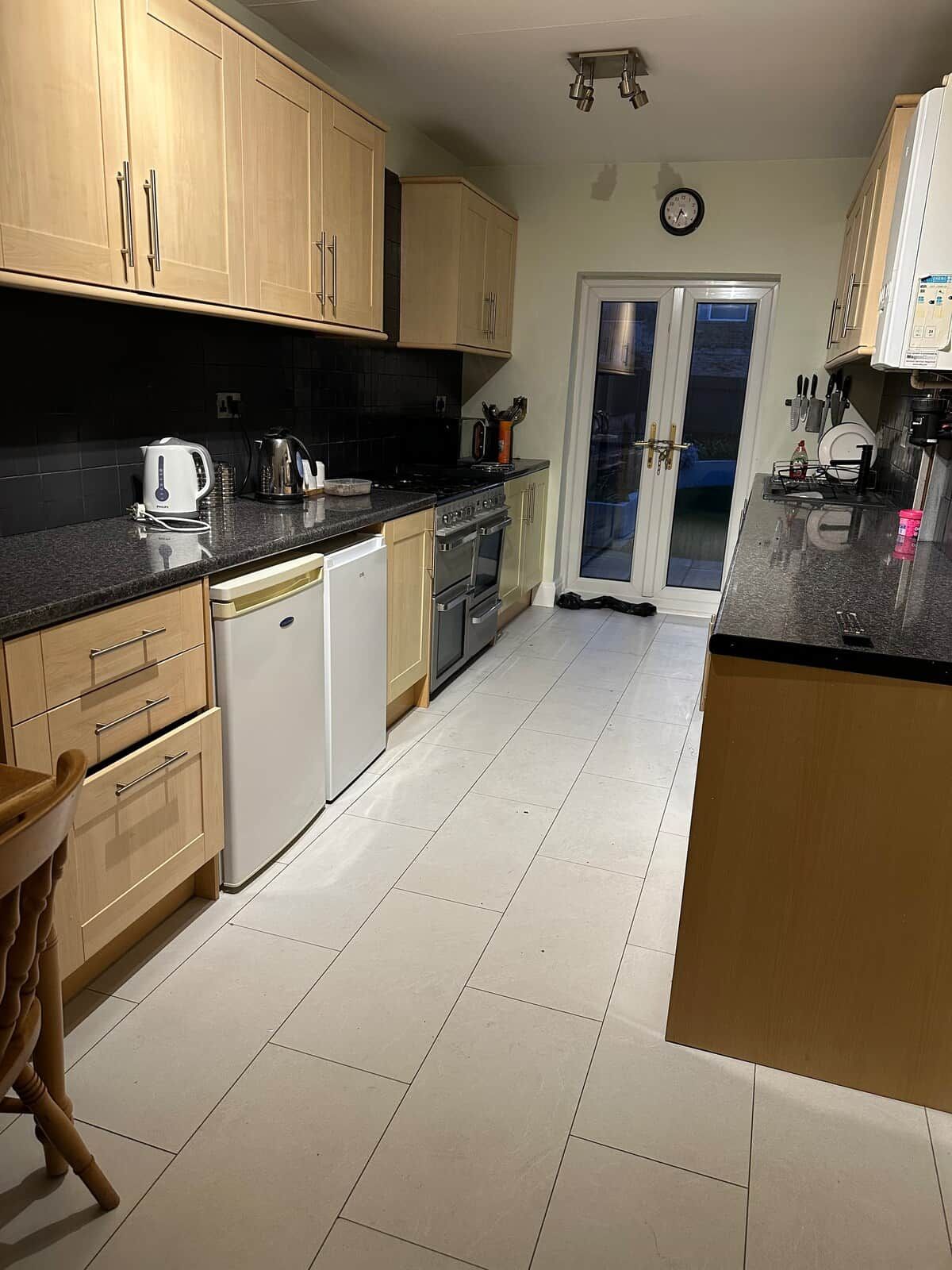 Een keuken met houten kastjes, een vaatwasser, een fornuis en een spoelbak.