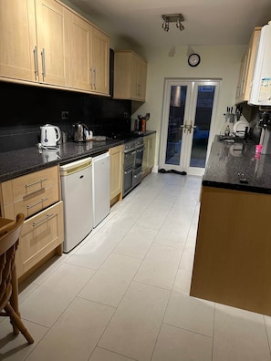 Una cocina con armarios de madera, lavavajillas, estufa y pileta.