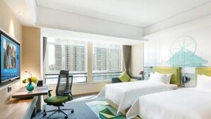 A hotel room with two beds, a desk, a chair, a TV, and a large window with a city view. - Hampton by Hilton Liaocheng (Liaocheng)