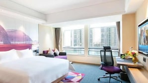 A hotel room with a large bed, a desk with a chair, a TV, and a window with a city view. - Hampton by Hilton Liaocheng (Liaocheng)